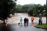 Bystanders watch the rising floodwaters