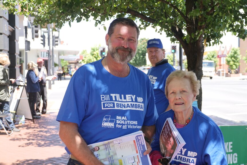 Bill Tilley poses next to an older woman both wearing blue campaign t-shirts