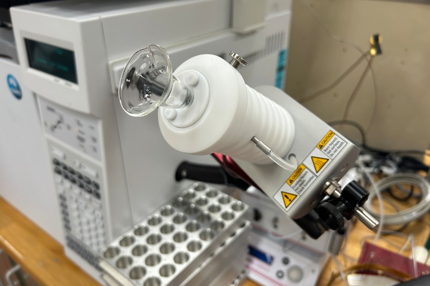 A small clear plastic cone mounted on an arm sticking out of the side of a piece of laboratory equipment