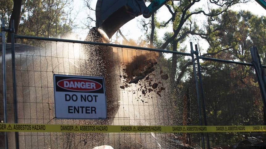 danger sign on fence with excavator