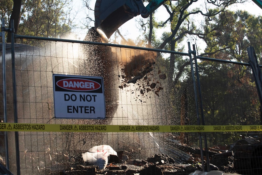 danger sign on fence with excavator