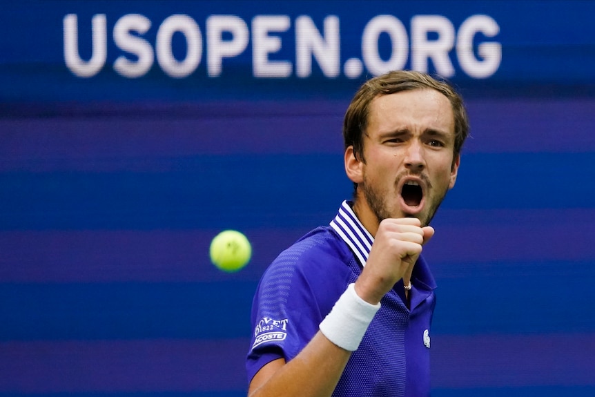 Daniil Medvedev shouts and clenches his fist in celebration as the ball bounces behind him at the US Open.