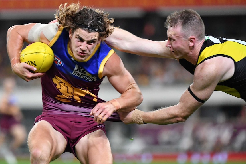 Jarrod Berry shrugs as Dylan Grimes tries to grab the back of his jersey