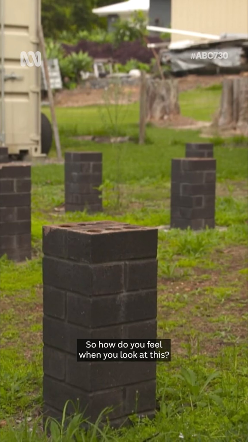 Stumps made from bricks sit atop a green grassy lawn with some patches of exposed earth also visible