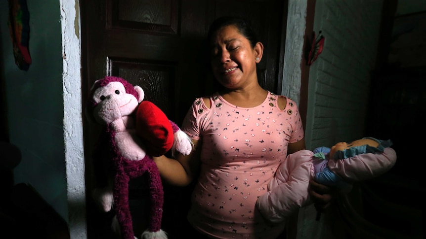 Rosa Ramirez sobs as she shows the toys that belonged to her granddaughter.