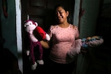 Rosa Ramirez sobs as she shows the toys that belonged to her granddaughter.