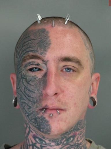 A man with half his face including his eyeball tattooed 