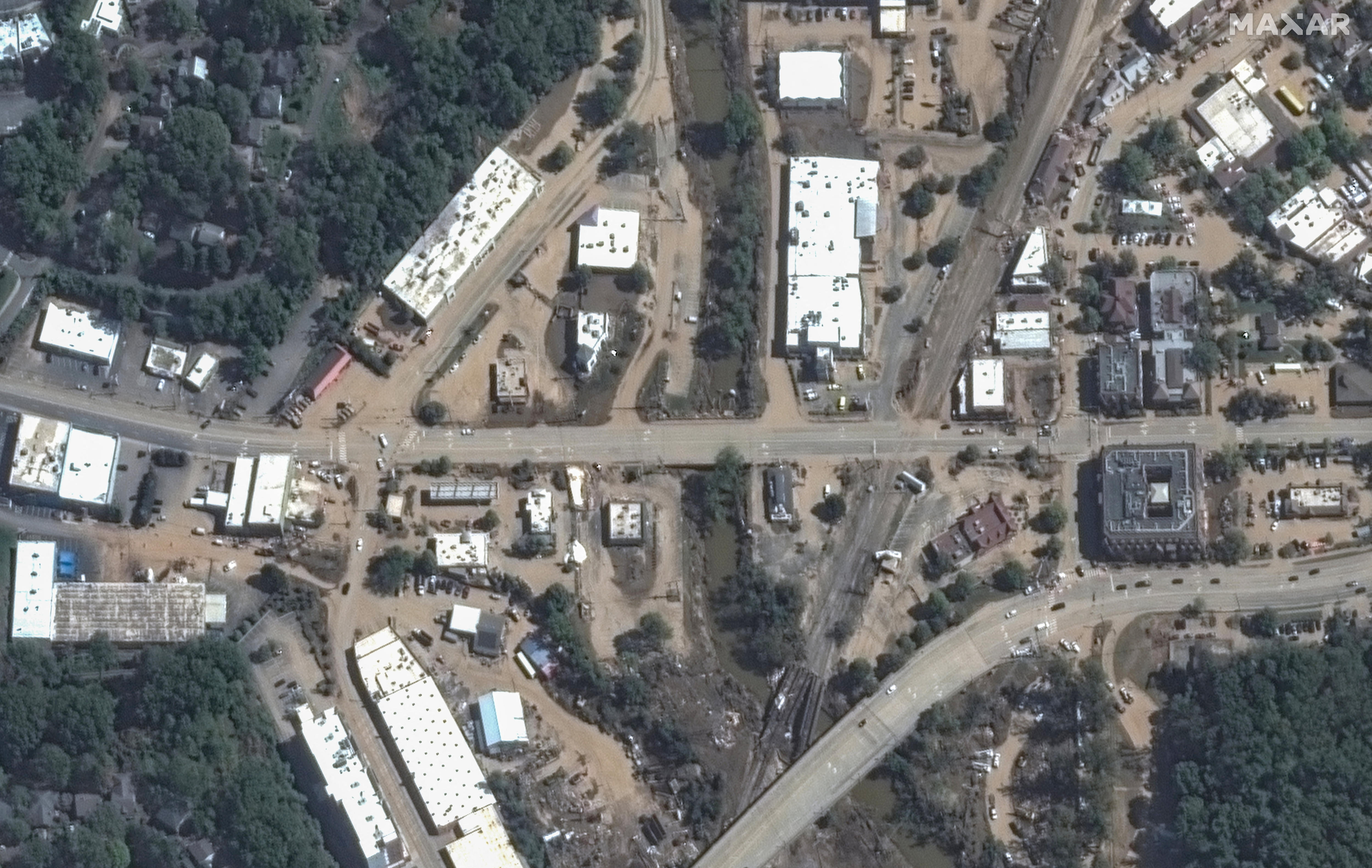 A satellite view shows mud and silt from flooding 