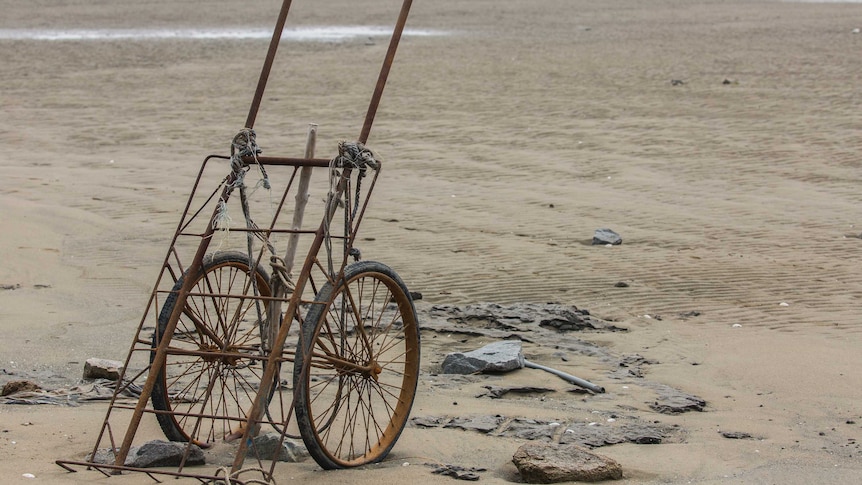 A discarded trolley on a beach