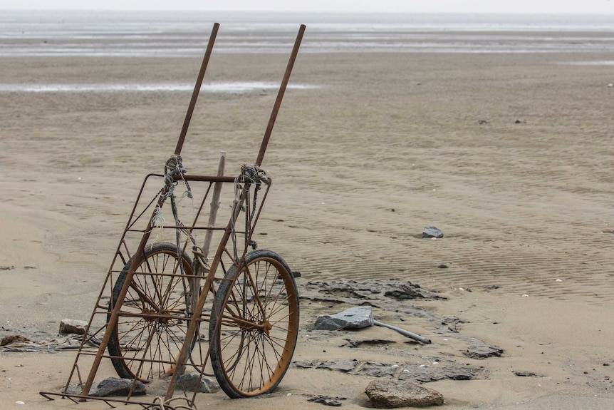 A discarded trolley on a beach