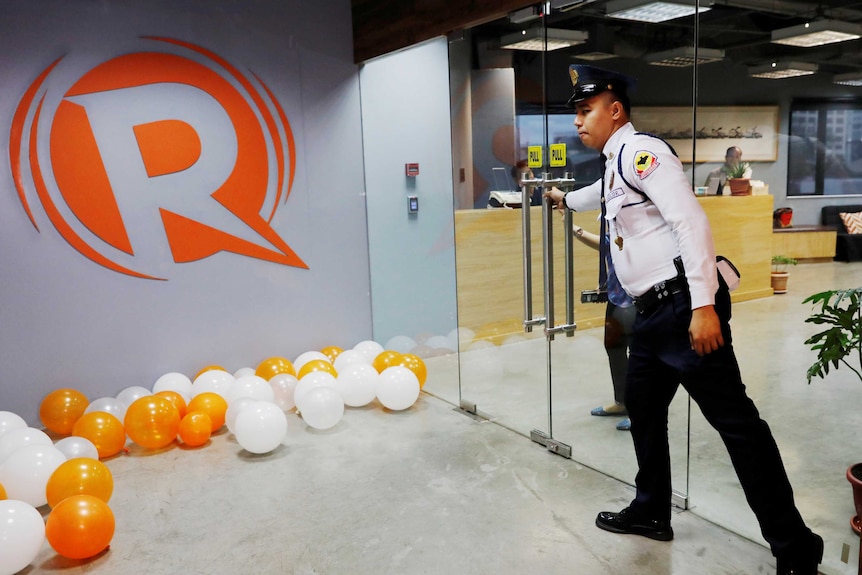 A guard opens a door at the office of Rappler.