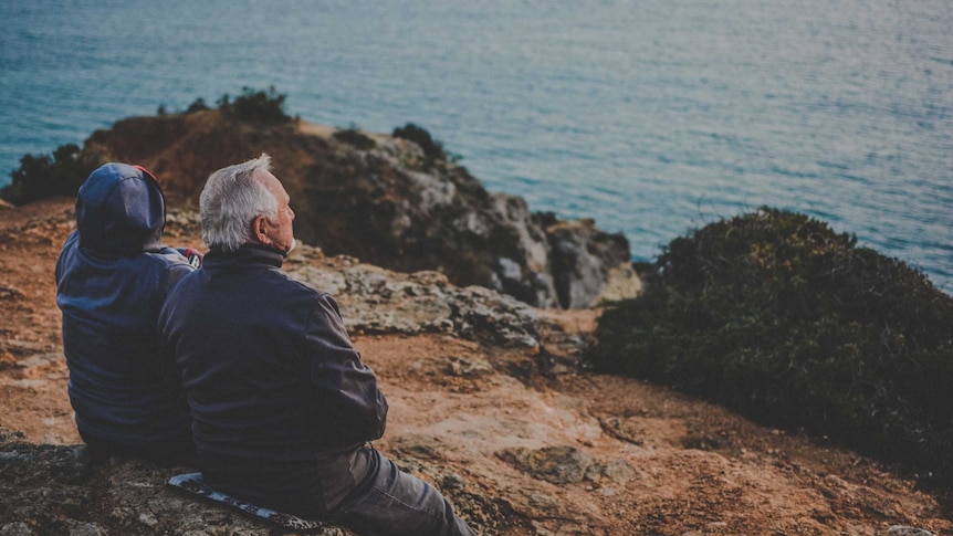 Two elderly people looking out to sea.