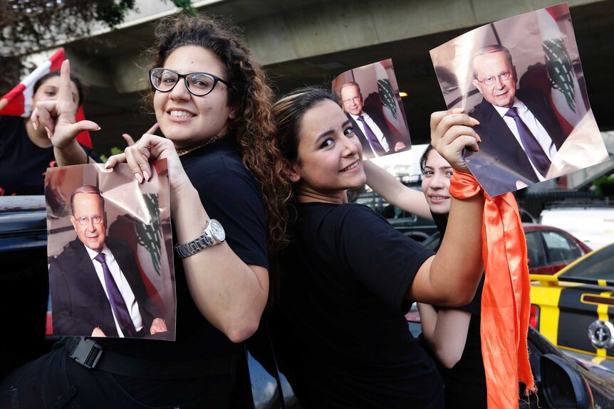 Aoun supporters hold his picture