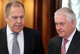 Sergey Lavrov and Rex Tillerson stand alongside each other both looking towards the ground.