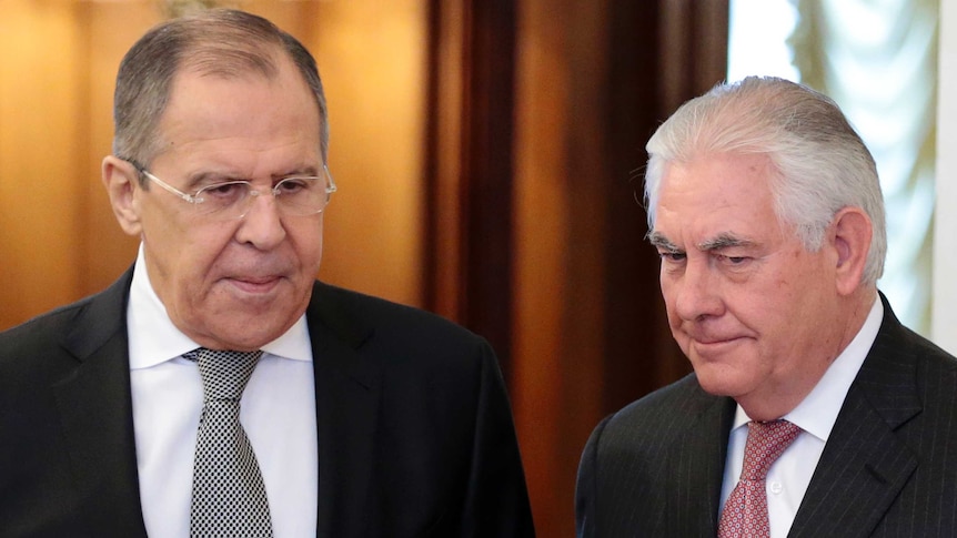 Sergey Lavrov and Rex Tillerson stand alongside each other both looking towards the ground.