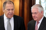 Sergey Lavrov and Rex Tillerson stand alongside each other both looking towards the ground.