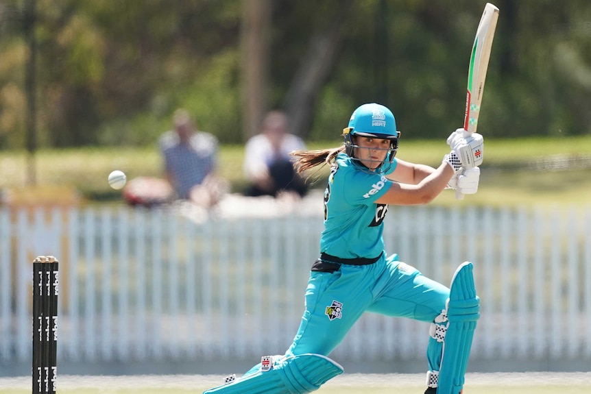 A female cricketer plays a cut shot during a Women's Big Bash League match.