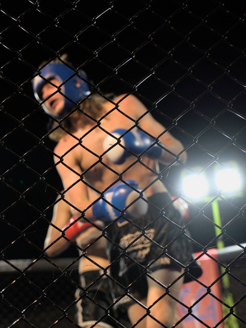 A kickboxing match seen through a fence.