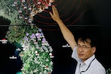 An official points at a map of the Korean peninsula showing seismic waves from a North Korean nuclear test in September.