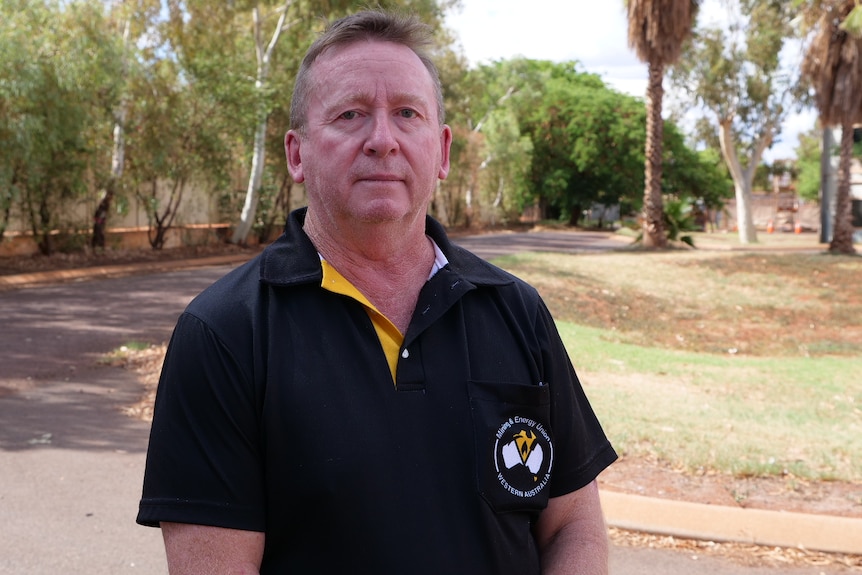 A man in a black shirt looks at the camera 