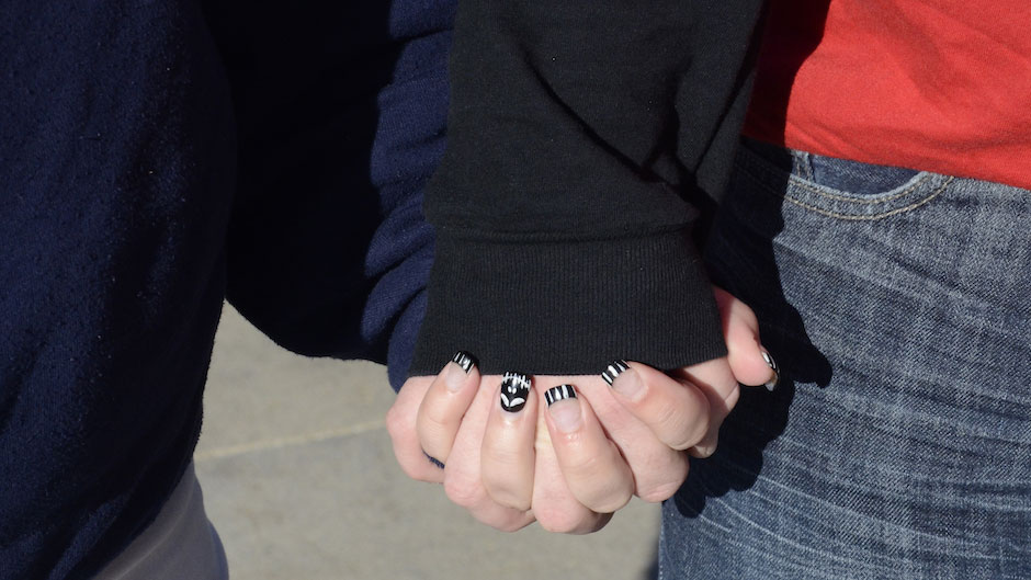 A young couple holds hands.