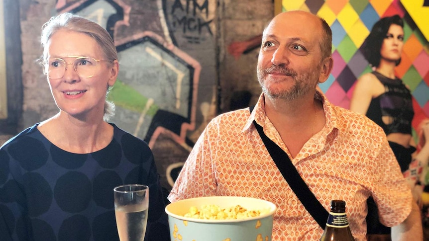 Carolle Walls and Leo Kaloglou sit at a table with popcorn and drinks at the Red Hill Cinemas Complex.