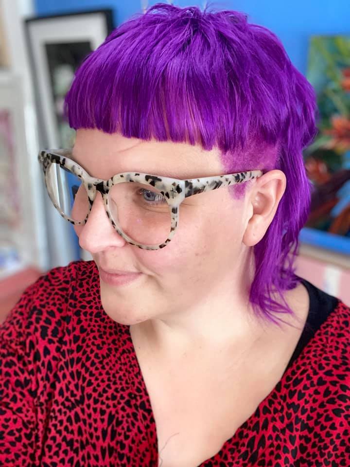 Selfie of a woman with a purple mullet. 