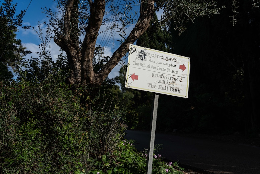 A sign at the entrance of the Oasis of Peace pointing visitors towards the school.