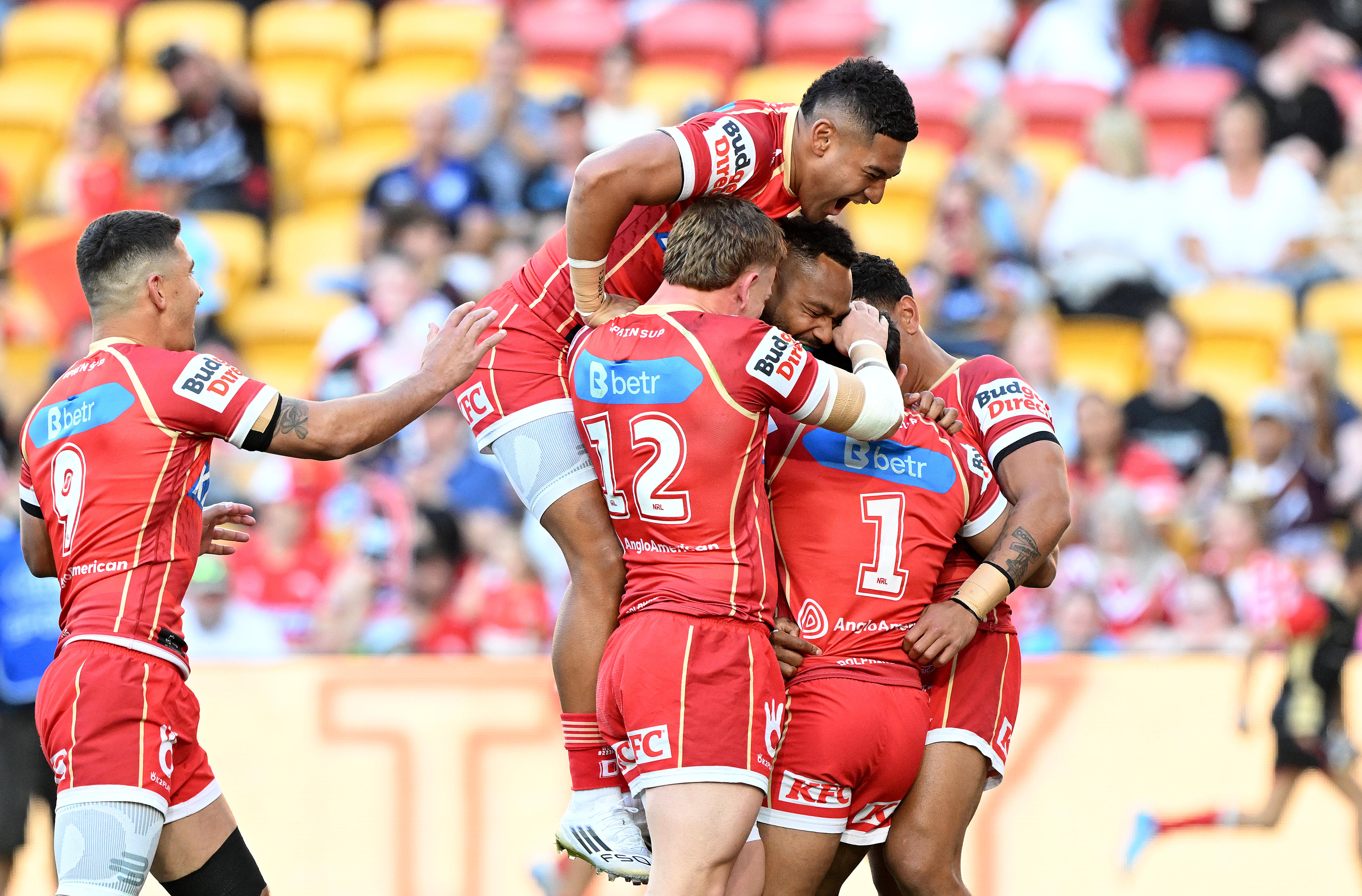 A group of rugby league players in red celebrate a try