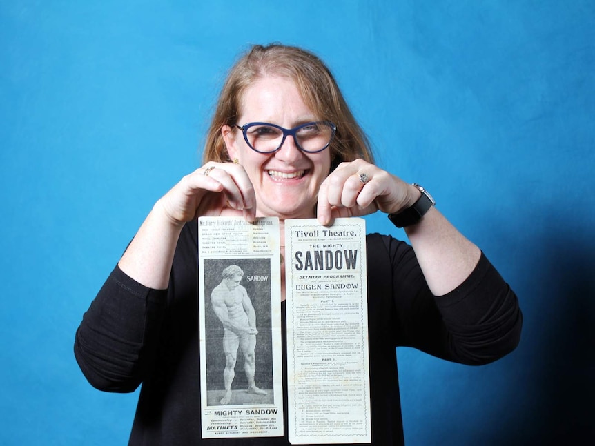 Erica Ryan, manager, Printed Australiana, National Library of Australia with Tivoli Theatre handbills for Eugen Sandow's show in 1902.