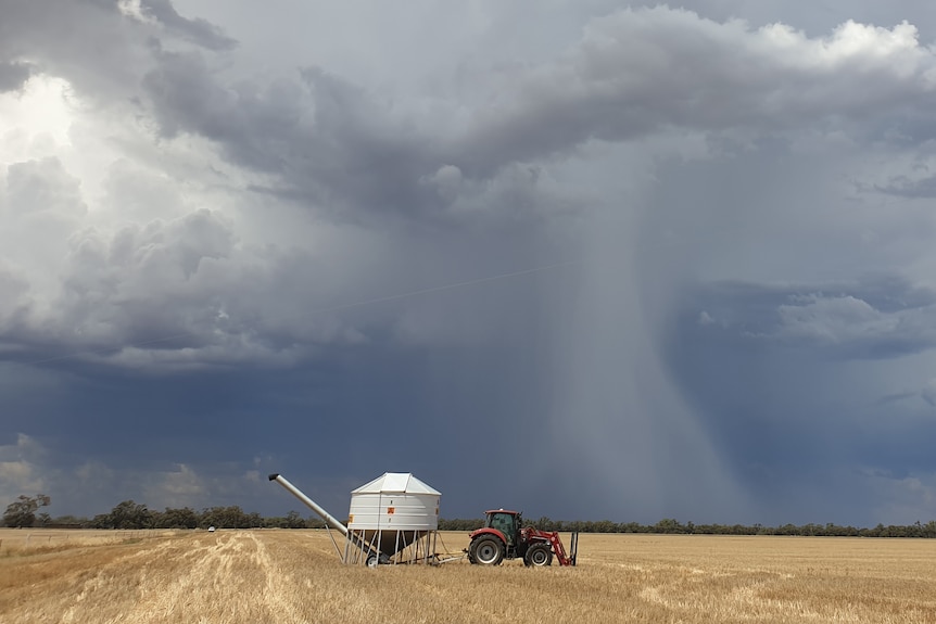 Tractor and silo in front of stormy skies