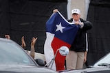 US President Donald Trump holds a flag of the state of Texas after receiving a briefing.