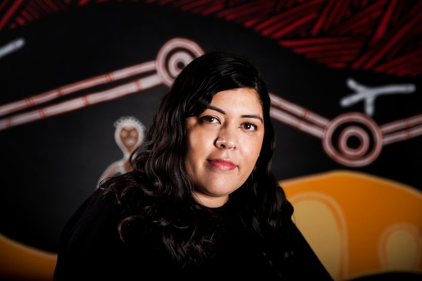 Nerita Waight in front of aboriginal art designs.