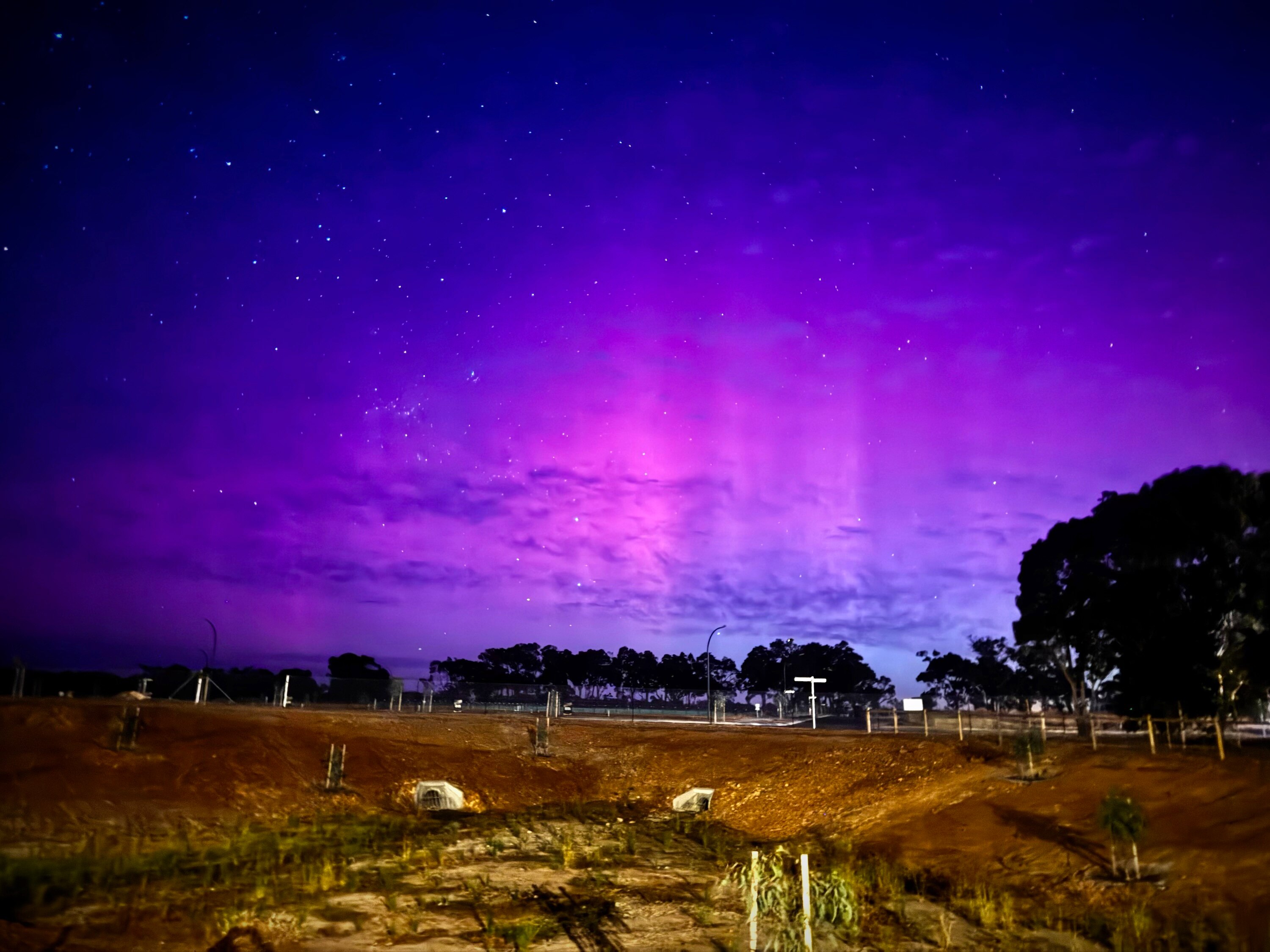 Aurora lights illuminate the sky in a rural location