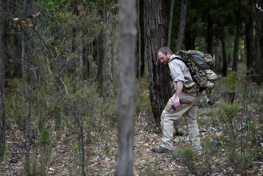 man in khaki clothes searching bushland