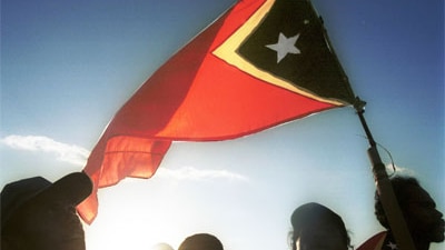 People wave the East Timorese flag during independence day celebrations in Dili, 2002 (ABC)
