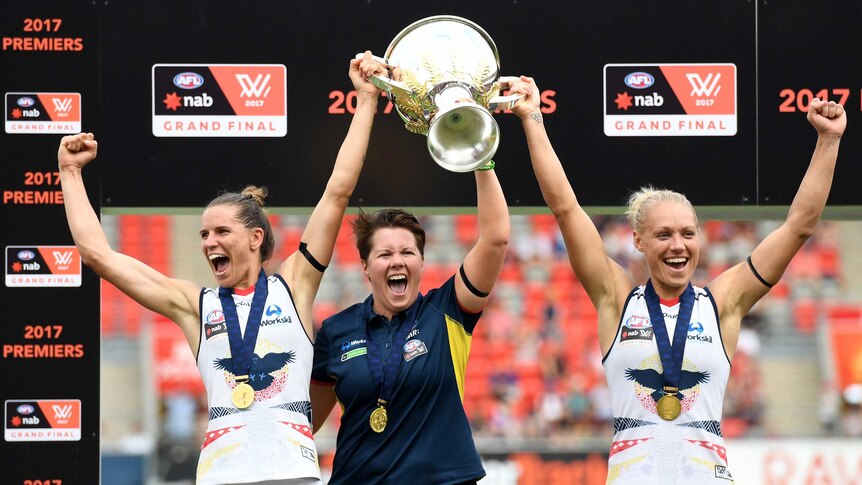 Adelaide co-captains Chelsea Randall and Erin Phillips hold up the AFLW trophy