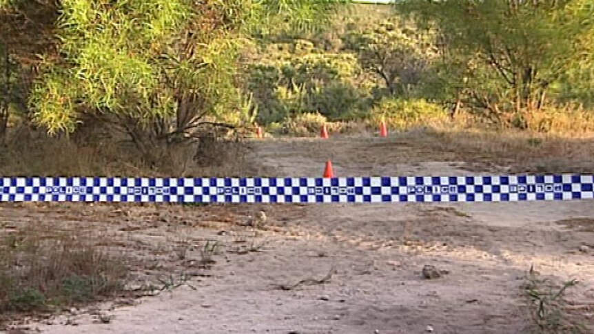 Police tape across a patch of scrubland