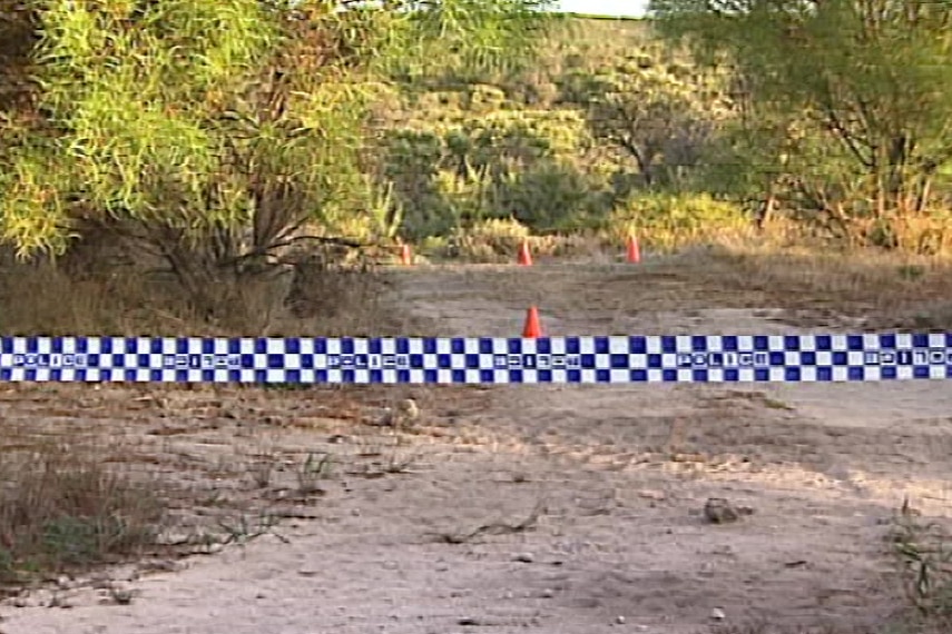 Police tape across a patch of scrubland