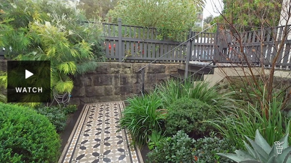 Tiled walkway in a lush garden. Has Video.