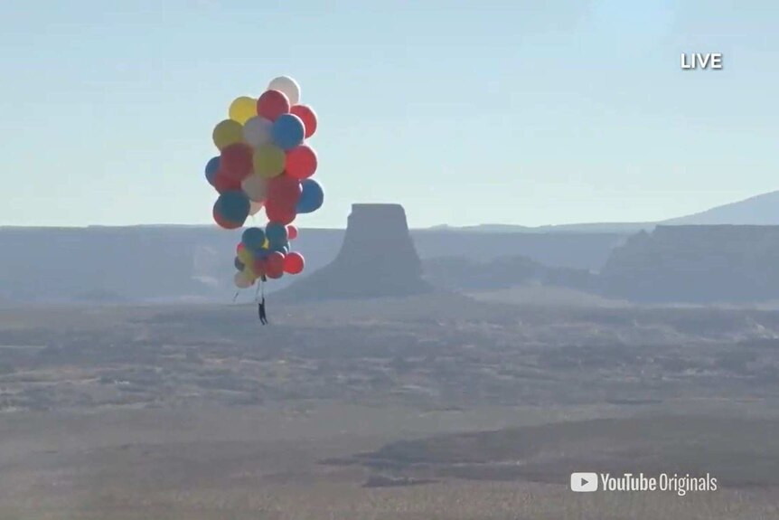 David Blaine floats over a desert attached to balloons in a stunt for YouTube called Ascension.