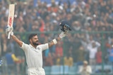 Virat Kohli raises his bat in smoggy conditions