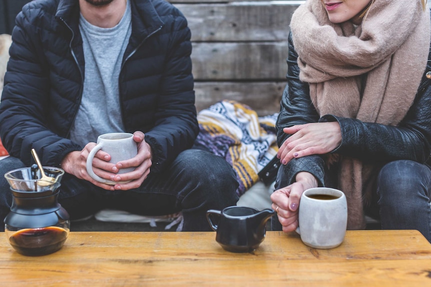 Man and woman drinking tea at a coffee table