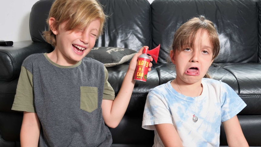 Fynn Goat, 8,  holding 'farts in a can' to ear of friend Mira Jung, 7, on school holidays.