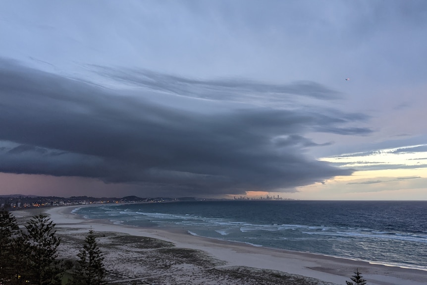 Des nuages ​​d'orage se préparent sur la plage de la Gold Coast méridionale du Queensland.