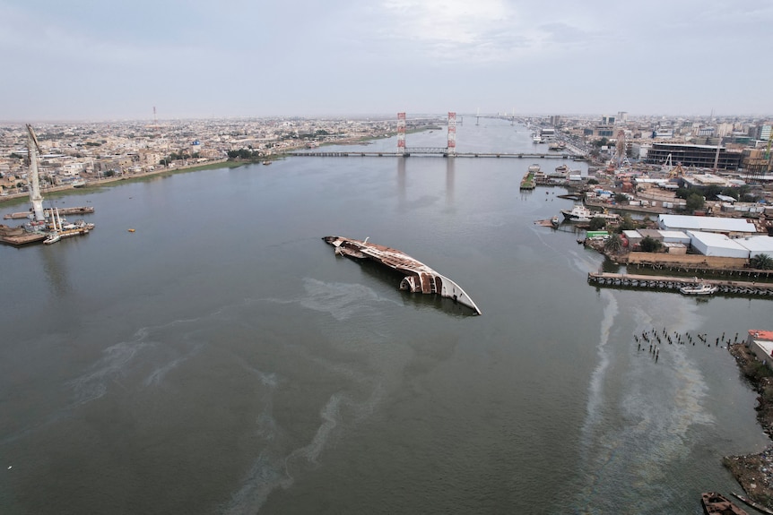 Aerial view of a capsized yacht in a canal