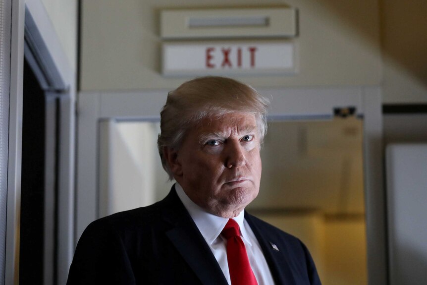 US President Donald Trump pauses as he talks to journalists.