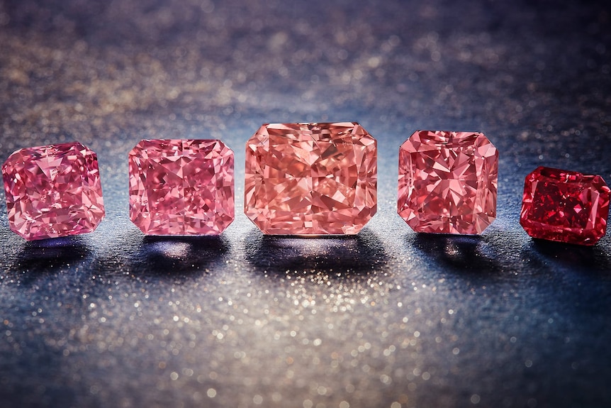 five diamonds of varying shades of pink and red