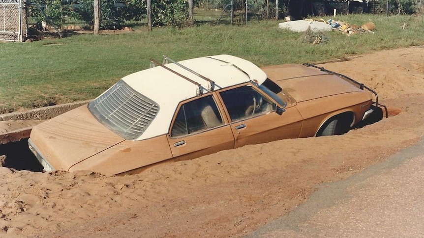 Car stranded in sinkhole in Charleville after 1990 flood.