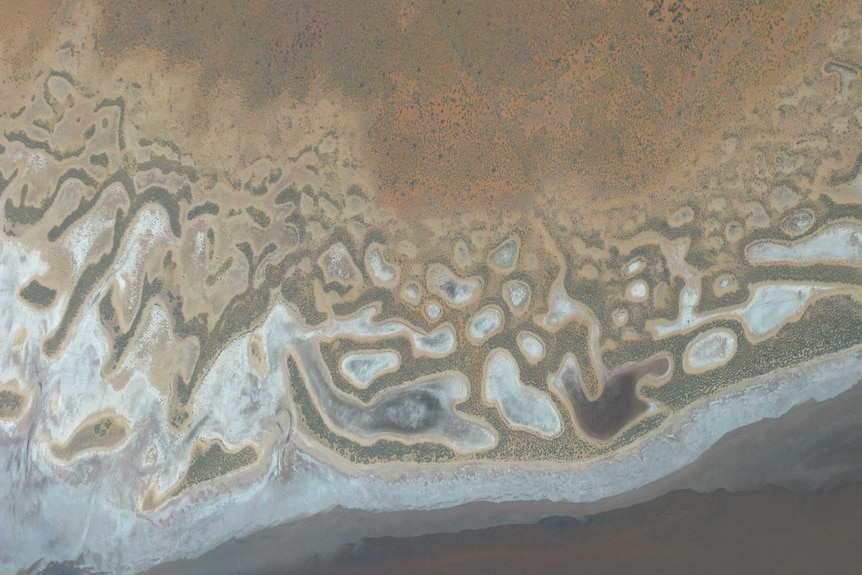 Aerial view looking straight down on  an intriguing pattern of a salt lake.